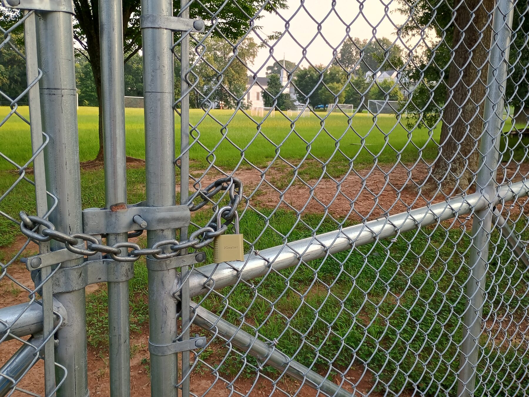 A locked chain-link gate in front of the soccer fields at Cheney Park